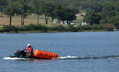 A jet ski pulls in buoys from the CrossFit Games at Marine Creek Lake, where an athlete drowned during the run swim event on Thursday, Aug. 8, 2024 in Fort Worth, Texas.