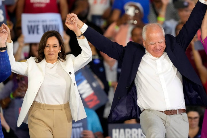 Vizepräsidentin Kamala Harris, demokratische Präsidentschaftskandidatin, und ihr Vizepräsident, der Gouverneur von Minnesota, Tim Walz, heben bei einer Wahlkampfveranstaltung am Mittwoch, dem 7. August 2024, in Romulus, Michigan, die Arme.