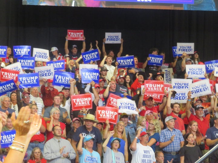 Attendees of the rally are pictured with more signs.