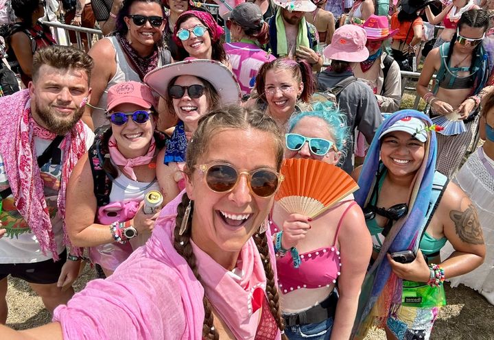 The author (center with orange fan) and her friends waiting in line to see Chappell at Bonnaroo in 2024.