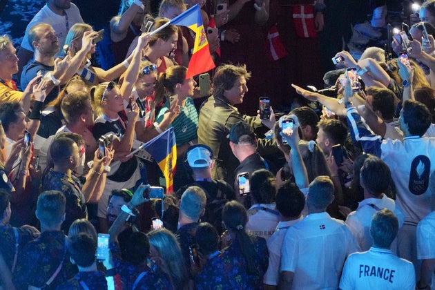 Ο Τομ Κρουζ λίγο μετά την προσγείωση του χαιρετά αθλητές. (AP Photo/Kin Cheung)