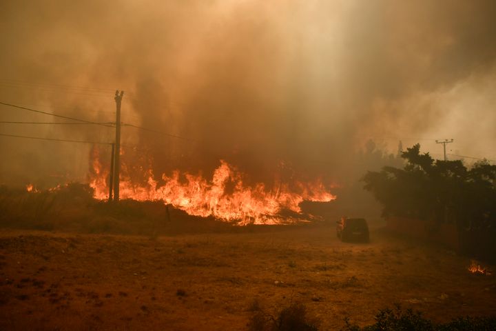 Ένα αυτοκίνητο φαίνεται κοντά στις φλόγες στη Διώνη, βορειοανατολικά της Αθήνας, Ελλάδα, Δευτέρα 12 Αυγούστου 2024. Εκατοντάδες πυροσβέστες με την υποστήριξη δεκάδων αεροπλάνων και ελικοπτέρων που έριχναν νερό έδιναν μάχη με τις φλόγες από το πρώτο φως της Δευτέρας, με μια μεγάλη δασική πυρκαγιά που ξεκίνησε την προηγούμενη ημέρα να μαίνεται ανεξέλεγκτη στις παρυφές της Αθήνας, υποδαυλισμένη από ισχυρούς ανέμους. (AP Photo/Michael Varaklas)