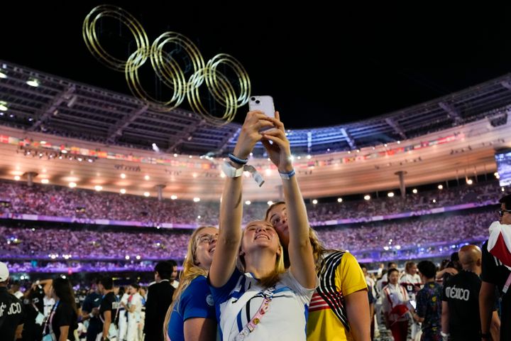 Athletes pose for a selfie during the 2024 Summer Olympics closing ceremony at the Stade de France, Monday, Aug. 12, 2024, in Saint-Denis, France. (AP Photo/Ashley Landis)