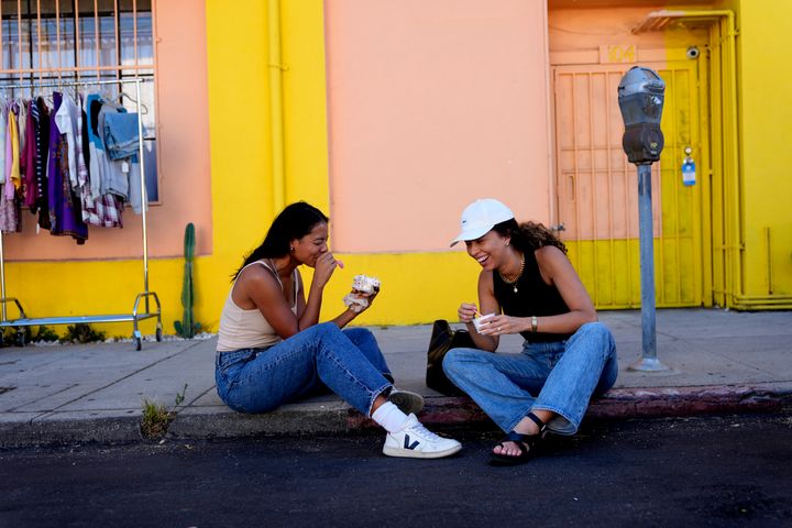 Nemesis R. (links) und Zoe Apple sitzen am 12. August 2024 auf einer Straße im Highland Park-Gebiet von Los Angeles und essen Eis, nachdem das Erdbeben von der Gegend um Los Angeles bis nach San Diego stark zu spüren war.