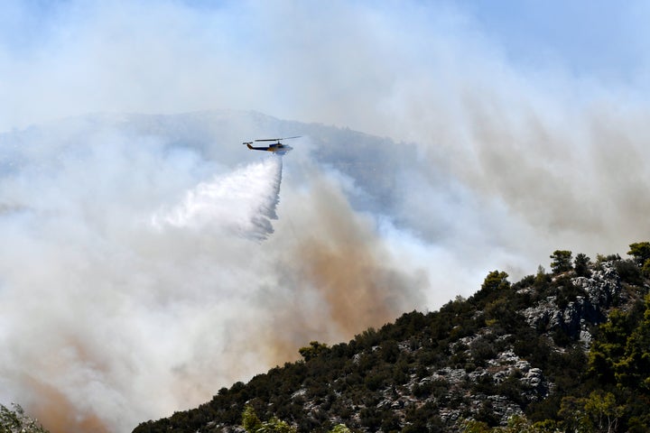 Ελικόπτερο της Πυροσβεστικής πραγματοποιεί ρίψη νερού σε φλεγόμενη πλαγιά κοντά στη Νέα Μάκρη - Αττική, 12 Αυγούστου 2024