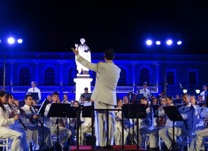 Ο Αρχιμουσικός σε διάλογο με τον Ποιητή με φόντο το Μεταβυζαντινό Μουσείο Ζακύνθου στα εθνικά χρώματα Φωτο Ανδριανή Στράνη