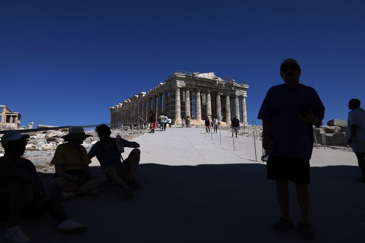 Αθήνα, 16 Ιουλίου: Επισκέπτες στην Ακρόπολη αναζητούν «καταφύγιο» από τον καυτό ήλιο στη σκιά του Ιερού Βράχου.