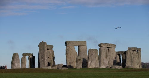 FILE - In this Tuesday, Dec. 17, 2013 file photo, visitors take photographs of the world heritage site of Stonehenge, in Wiltshire England. The prehistoric monument of Stonehenge in southern England was closed to visitors Saturday, Dec. 5, 2020, in the afternoon after protesters staged a “mass trespass” against the British government’s road-building plans, which includes a new tunnel near the World Heritage Site. The protesters, who described themselves as an alliance of local residents, ecologists, activists, archaeologists and pagans, gathered at Stonehenge around midday. (AP Photo/Alastair Grant, File)