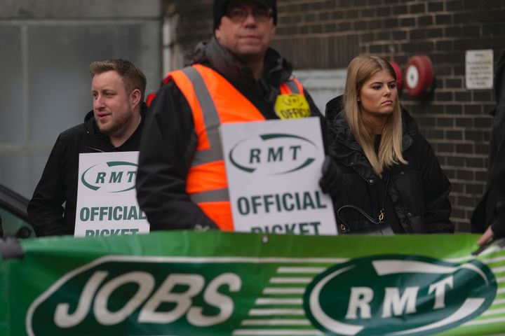 Demonstrators stage a protest outside a station in London, Wednesday, Jan. 4, 2023. Members of the Rail, Maritime and Transport union are staging a fresh round of strikes that will disrupt services all week. Around half of the U.K.'s railway lines are closed, and only one-fifth of services are running amid a long-running dispute over pay and working conditions. (AP Photo/Kin Cheung)