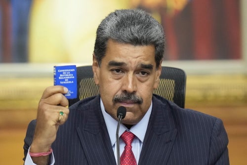 Venezuelan President Nicolas Maduro holds a small copy of the constitution as he gives a news conference at Miraflores presidential palace in Caracas, Venezuela, on July 31, 2024, three days after his disputed reelection.