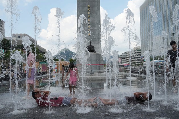 Παιδιά δροσίζονται σε δημόσιο συντριβάνι στη Σεούλ.