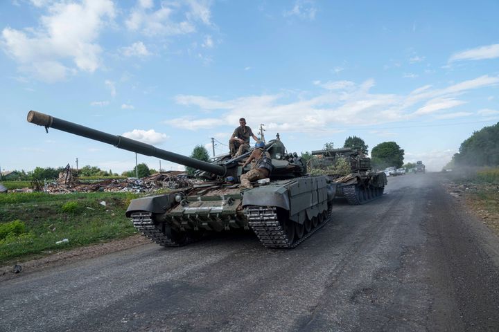 Ukrainian servicemen ride atop a tank after returning from Russia near the Russian-Ukrainian border in Sumy region, Ukraine.