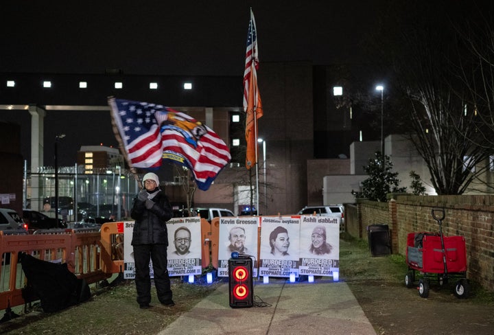 A woman waves a flag at a vigil for January 6th defendants outside the DC jail in Washington, D.C., on Jan. 3. Bundled against the winter cold, a dozen people outside Washington's jail pray, sing and shout their support for inmates held over the violent attack on the Capitol three years ago that sought to overturn Donald Trump's election defeat.