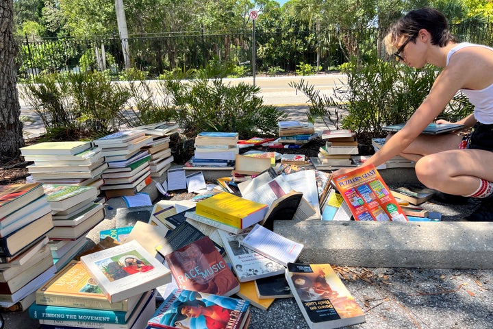 FILE - A student sorts through books before sending them to the landfill on the campus of New College of Florida in Sarasota, Fla., Thursday, Aug. 15, 2024. (Steven Walker/Sarasota Herald-Tribune via AP)