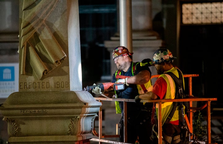 FILE — Workers loosen the base of a Confederate monument Thursday, June 18, 2020, in Decatur, Ga. The 30-foot obelisk in Decatur Square, erected by the United Daughters of the Confederacy in 1908, was ordered by a judge to be removed and placed into storage indefinitely. (AP Photo/Ron Harris)