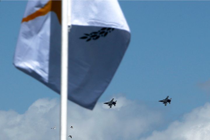 Greece's air force war planes flies over the military parade behind a Cyprus flag,