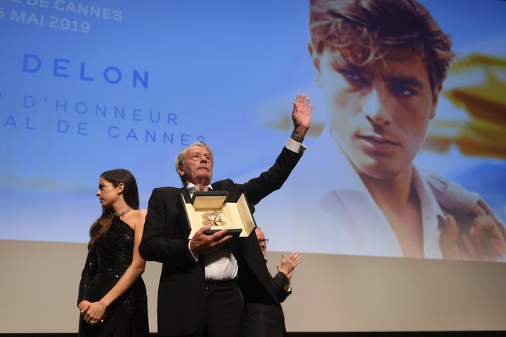 In this Sunday, May 19, 2019 photo, actor Alain Delon, centre, holds his honorary Palme D'Or award at the 72nd international film festival, Cannes, southern France. (Photo by Arthur Mola/Invision/AP)