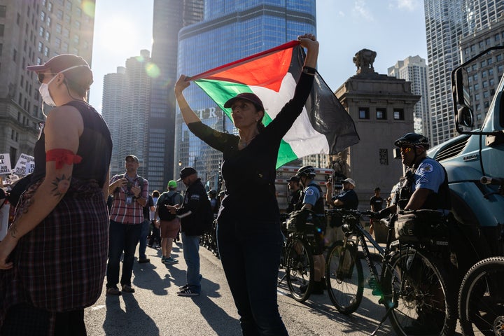 CHICAGO, ILLINOIS - AUGUST 18: A demonstrator holds up a Palestinian flag during a protest ahead of the Democratic National Convention on August 18, 2024 in Chicago, Illinois. The convention runs from August 19-22. (Photo by John Moore/Getty Images)