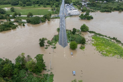 La Plata river floods a road after Tropical Storm Ernesto passed through Toa Baja, Puerto Rico, on Aug. 14, 2024.