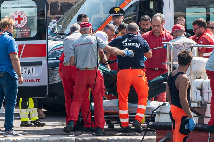 Rescuers recover the body of one of the victims of the UK flag vessel Bayesan that sunk early Monday off the Sicilian village of Porticello near Palermo.