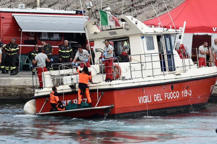 Italian Firefighters scuba divers bring ashore in a green bag the body of one of the victims of the UK flag vessel Bayesian, Wednesday, Aug. 21, 2024. (AP Photo/Salvatore Cavalli)