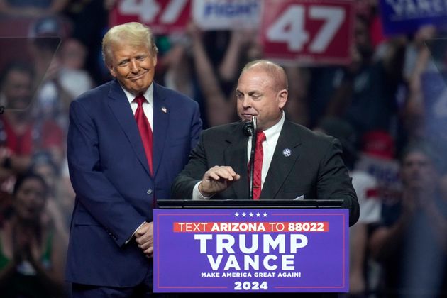 The president of the Arizona Police Association, Justin Harris, right, pauses while speaking as Republican presidential nominee former President Donald Trump listens at a campaign rally Friday, Aug. 23, 2024, in Glendale, Ariz.