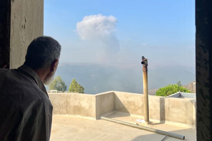 A man watches smoke rise after an Israeli airstrike in the southern Lebanese village of Qsair on August 25, 2024, as ongoing tensions escalate along the border and fighting continues between Israel and Hamas militias in the Gaza Strip. (Photo by AFP) (Photo by -/AFP via Getty Images)