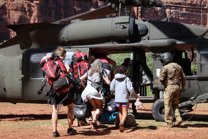 U.S. Army soldiers of the Arizona National Guard guide tourists trapped by flash flooding on Saturday into a UH-60 Blackhawk helicopter in Supai, Arizona.