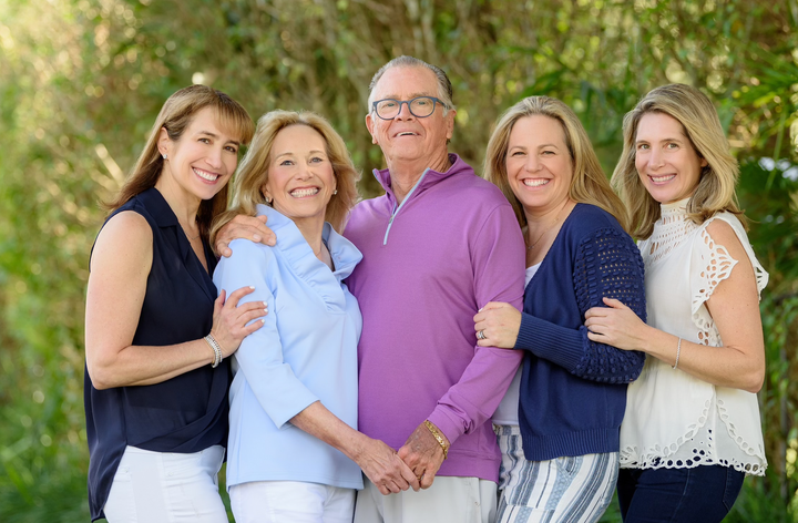 The author (second from right) with her mother (second from left), her adoptive father John (center), and her sisters in Florida in 2023.