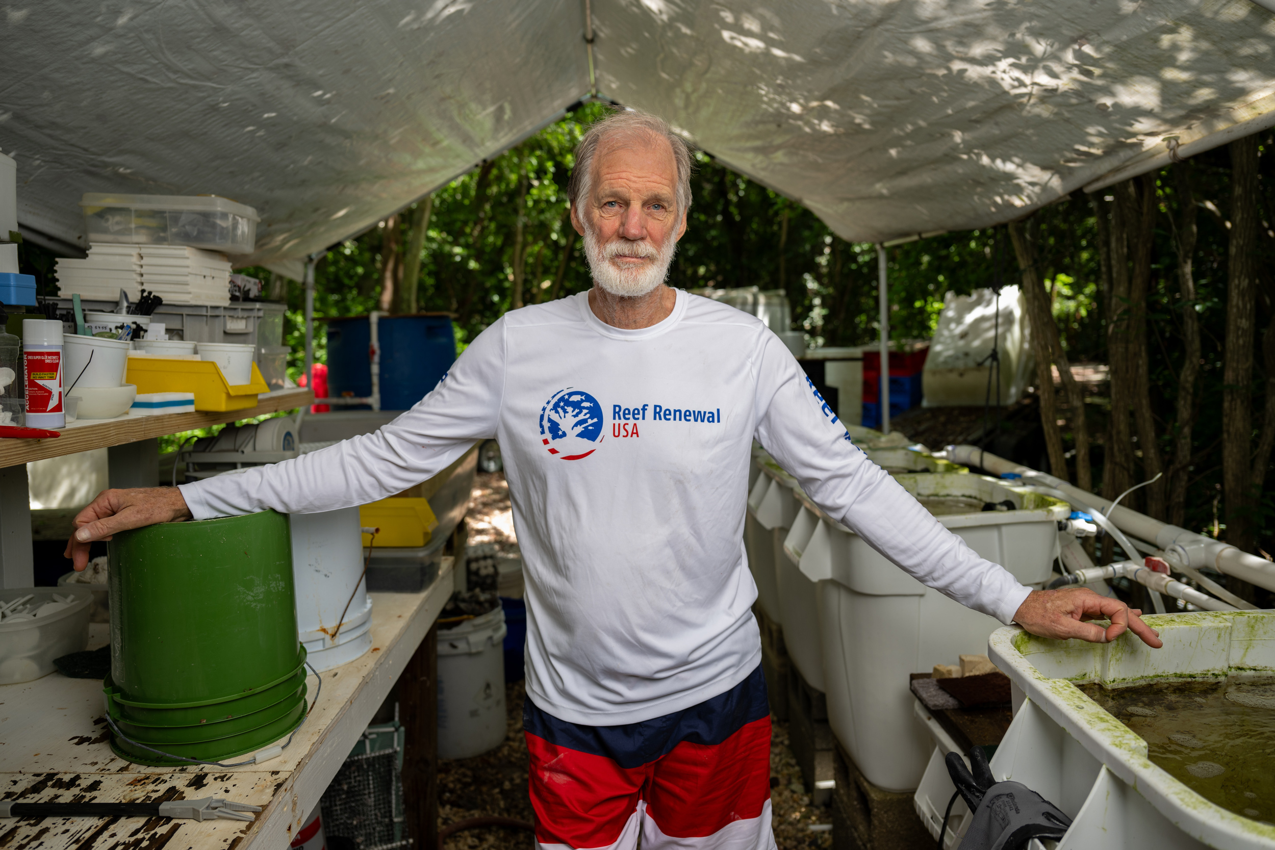 Ken Nedimyer stands next to saltwater baths in his backyard coral restoration workshop in Tavernier, Florida, on July 14. Nedimyer is the founder of the coral restoration organization Reef Renewal USA.