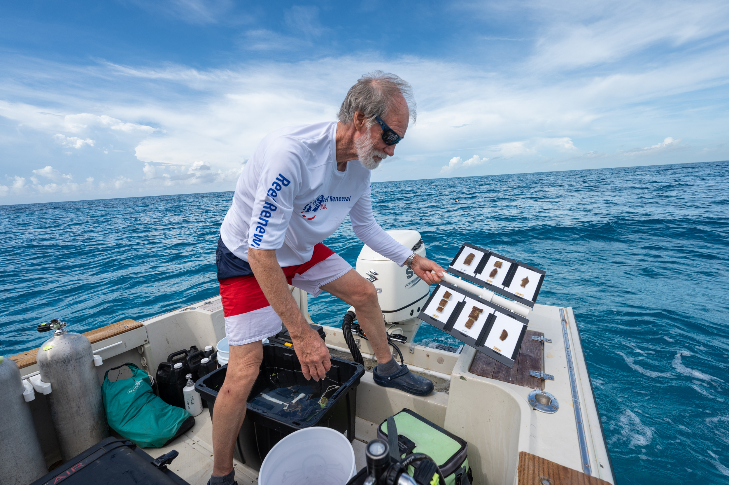 Nedimyer intentionally drops a tray of coral specimens into the ocean directly above his coral nursery, about 3 miles offshore of Tavernier, Florida, on July 13. After donning scuba equipment, he will collect the specimen trays he dropped overboard and install them on 