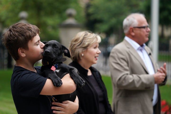 保護施設から迎えた犬のスカウトを紹介するミネソタ州知事のティム・ウォルズ氏（右）隣は妻のグウェン・ウォルズさんで犬を抱いているのはふたりの子どものガス・ウォルズさん（左）（2019年9月5日）