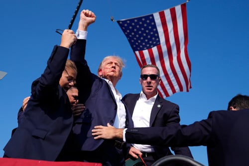 Republican presidential candidate former President Donald Trump is surrounded by U.S. Secret Service agents after being shot at a campaign rally, Saturday, July 13, 2024, in Butler, Pa.