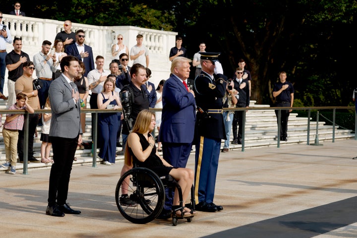 ARLINGTON, VIRGINIA - AUGUST 26: Republican presidential nominee, former U.S. President Donald Trump looks on alongside Marlon Bateman (L), Marine Cpl. Kelsee Lainhart and U.S. Marine Corps. Sergeant Tyler Vargas-Andrews during a wreath laying ceremony to honor the lives of those who died at the Abbey Gate Bombing at the Tomb of the Unknown Soldier at Arlington National Cemetery on August 26, 2024 in Arlington, Virginia. Monday marks three years since the August 26, 2021, suicide bombing at Hamid Karzai International Airport, which killed 13 American service members. (Photo by Anna Moneymaker/Getty Images)