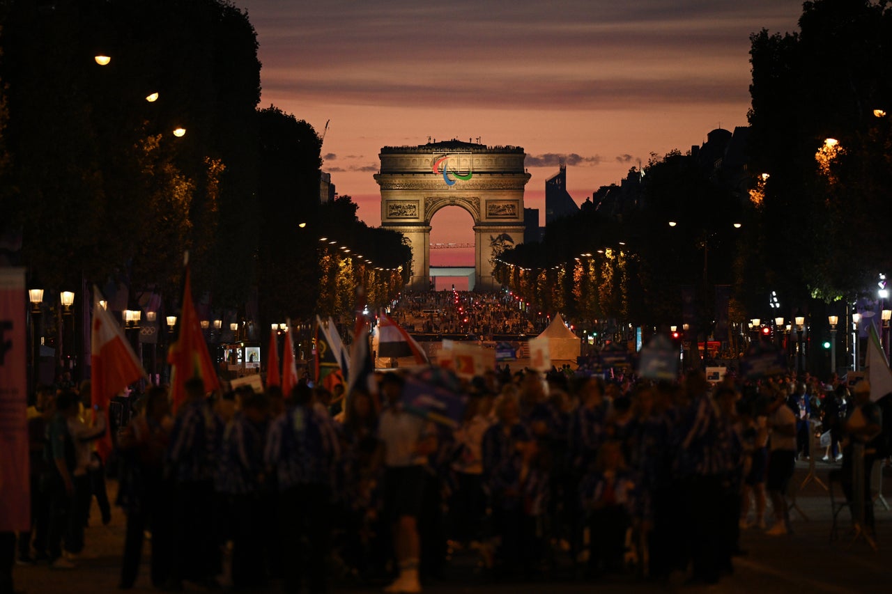 The sunset over the Arc de Triomphe as athletes parade towards the Place de la Concorde.