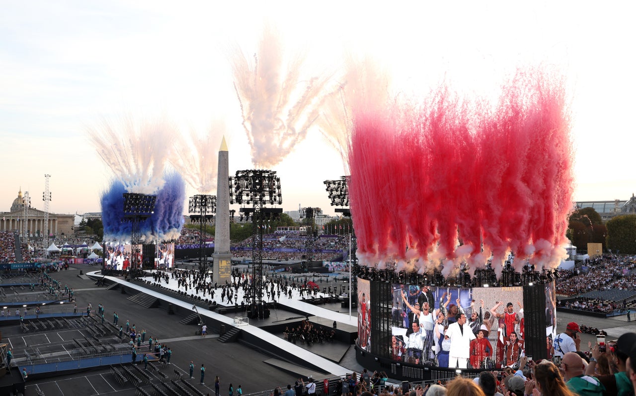 Smoke is released in the colors of the French flag whilst dancers perform during the "discord" act. The theme of the ceremony was "From Discord to Concord."