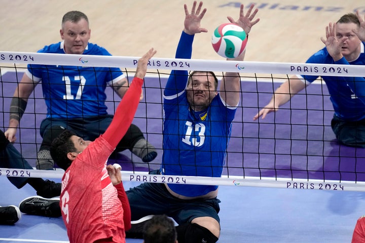 Dmytro Melnyk of Ukraine tries to block the ball during the men's preliminary round Sitting Volleyball game against Iran at the 2024 Paralympics, Friday, Aug. 30, 2024, in Paris, France. (AP Photo/Christophe Ena)