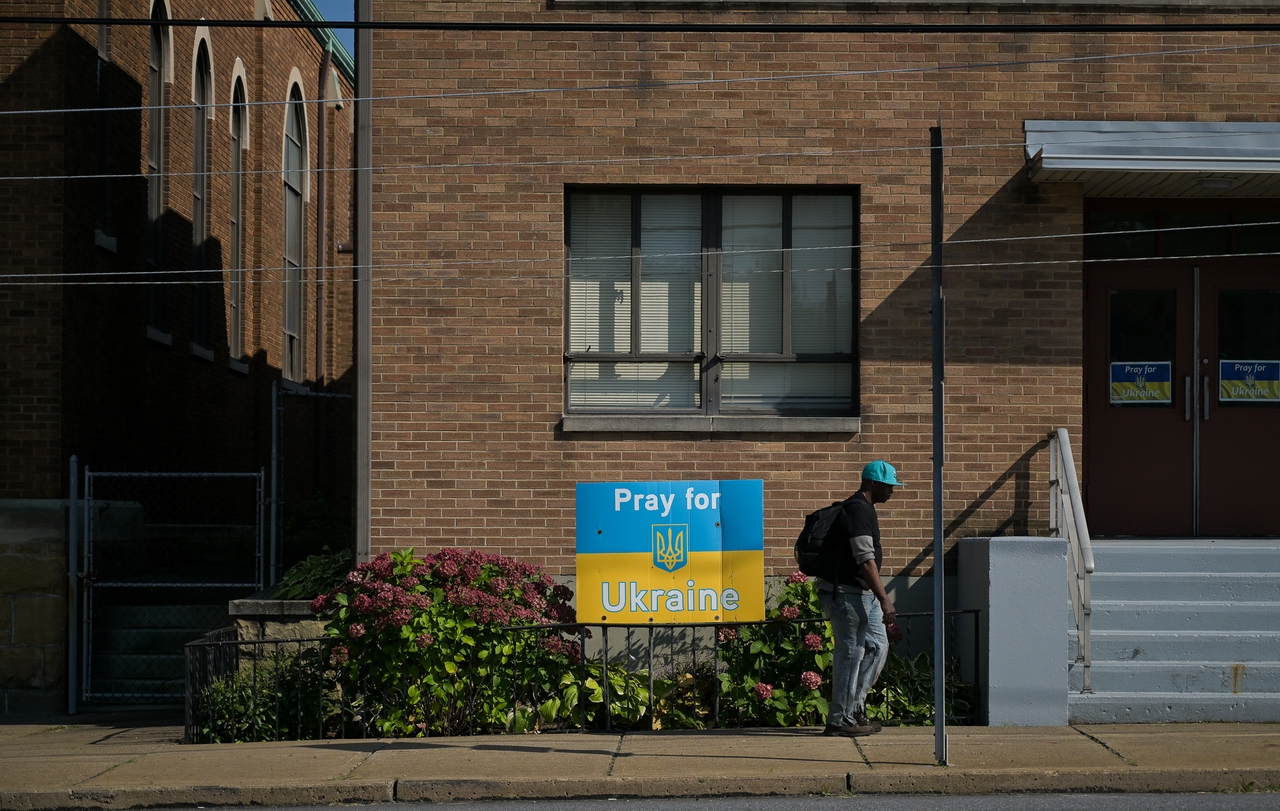 A man walks past a sign in support of Ukraine in Scranton.