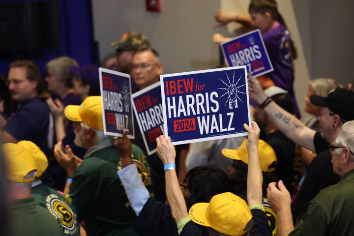 People wave campaign signs during a campaign event for Harris at IBEW Local Union #5 in Pittsburgh, Pennsylvania.