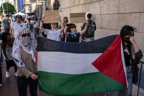 Freshmen Columbia and Barnard University students Lila and Shoshana raise signs while pro-Palestinian supporters protest outside Columbia University, Tuesday, Sep. 3, 2024, in New York.