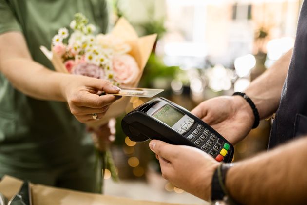 Close up of a young woman paying for a bouquet with her credit card