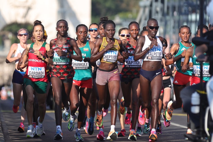 Rebecca Cheptegei (yellow-striped singlet), who's pictured competing in the world championships last year, died at age 33 after being lit on fire by her partner.