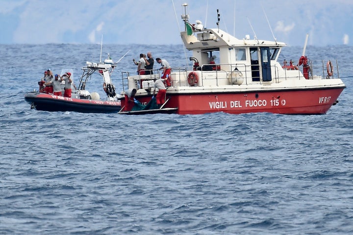 Italian Firefighters scuba divers bring ashore in a green bag the body of one of the victims of the sinking on Aug. 21.