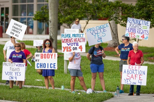 People hold up signs during an abortion rights rally on the second anniversary of the Supreme Court ruling to overturn Roe v. Wade in West Palm Beach, Florida, on June 24.