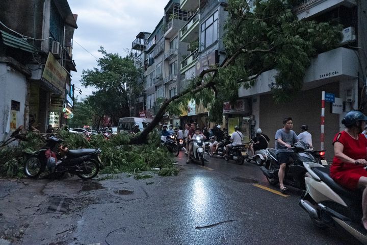 Η κυκλοφορία κινείται αργά μπροστά από πεσμένα δέντρα στους δρόμους του Ανόι, Βιετνάμ, Κυριακή 8 Σεπτεμβρίου 2024. (AP Photo/Aniruddha Ghosal)