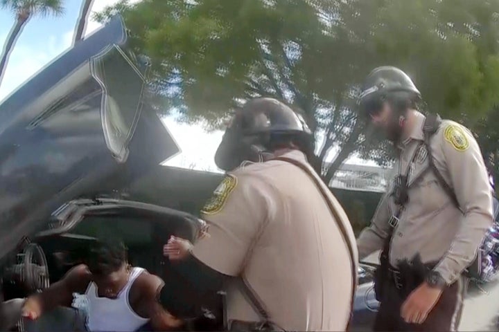 Police body camera video shows an officer dragging Miami Dolphins receiver Tyreek Hill out of his sports car by his arm and head and then forcing him face first onto the ground after Hill put up the window of his vehicle. (Miami-Dade Police Department)