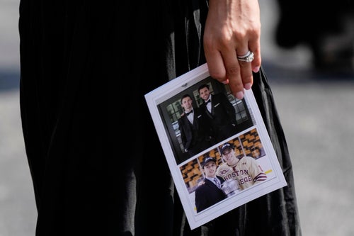 A mourner holds a program following Monday's memorial service.