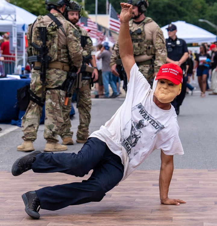 A breakdancer in a Trump mask performs on the street before a rally for Trump in Johnstown.