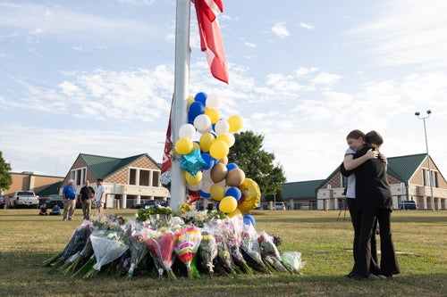Students embrace near a makeshift memorial at Apalachee High on Sept. 5 in Winder.
