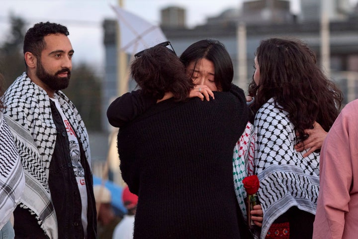 University of Washington law student Sue Han (C, facing) is hugged after speaking at a vigil on Seattle's Alki Beach for her slain friend Aysenur Ezgi Eygi, on Wednesday, Sept. 11, 2024. Israeli soldiers killed the 26-year-old human rights activist and University of Washington graduate while she was serving as an international observer for Palestinians in the occupied West Bank. Left is another of Eygi's friends, Yoseph Ghazal.